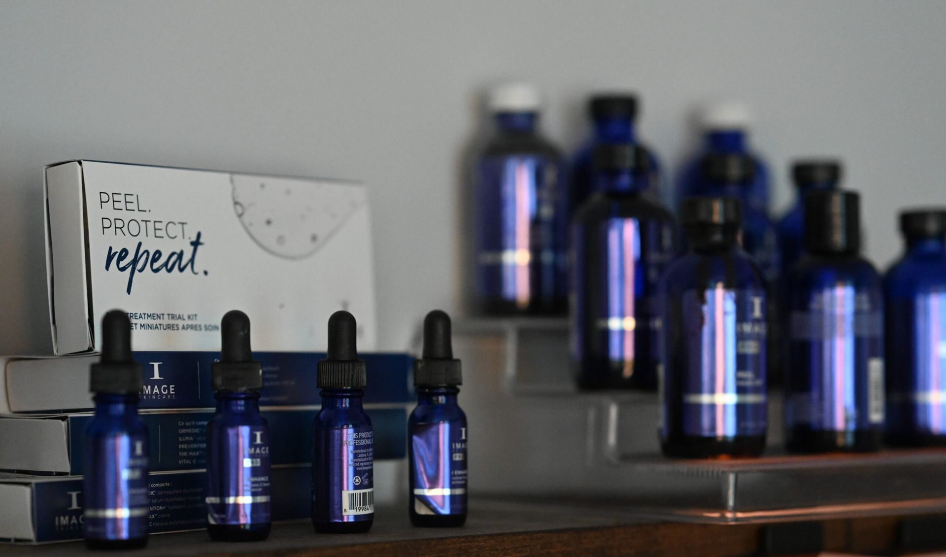 Bottles and boxes of blue skincare products on a shelf, with a 