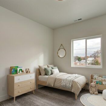 A child's bedroom with a single bed, a light wood dresser with books on top, a wall mirror, and a small bookcase.