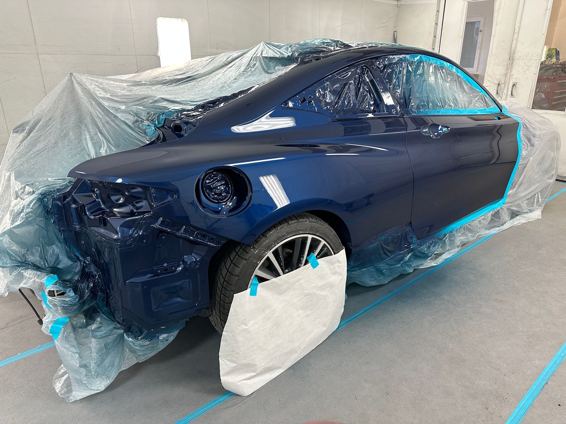 A black car is being repaired in a garage after.