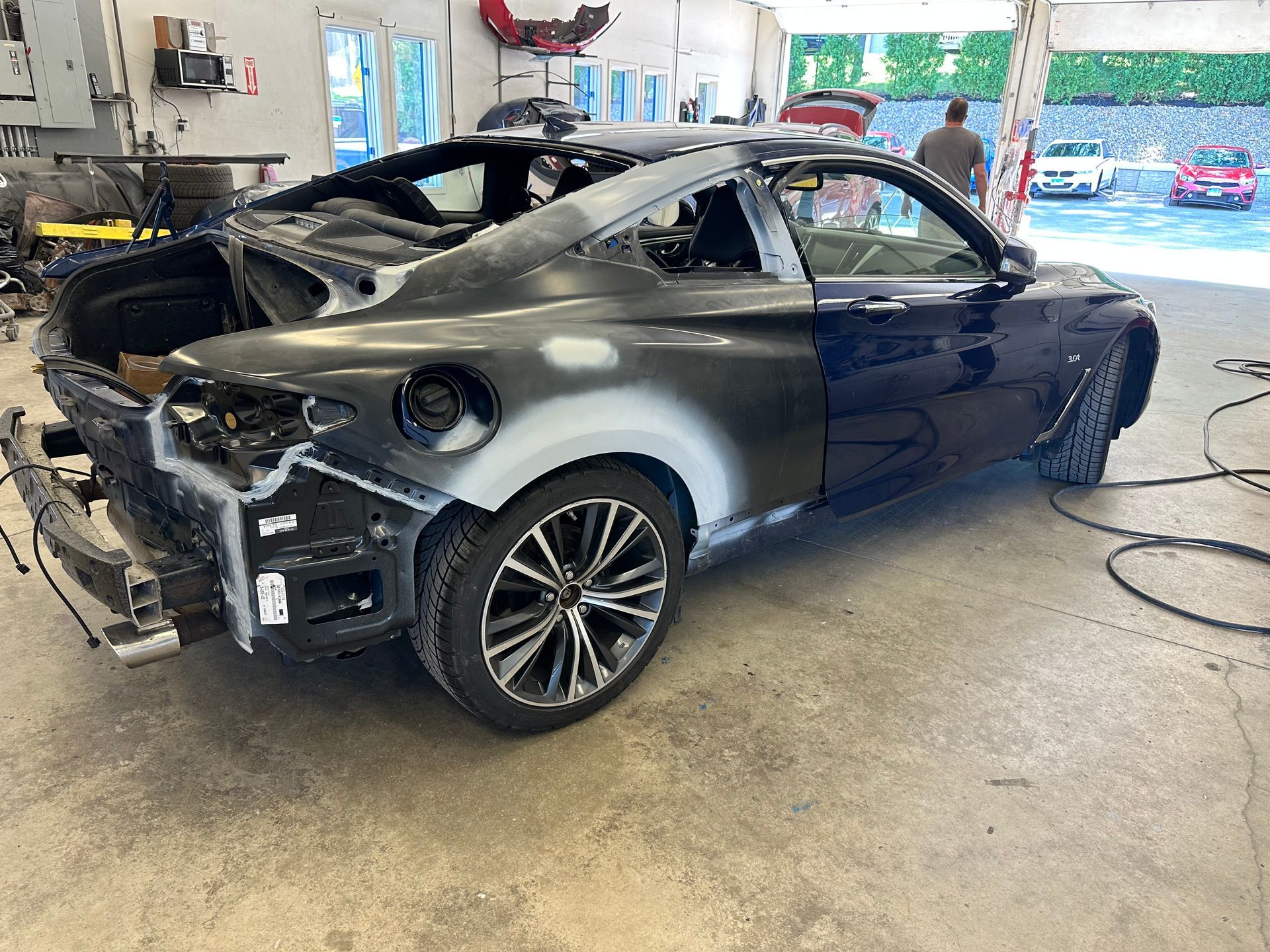 A black car is being repaired in a garage before