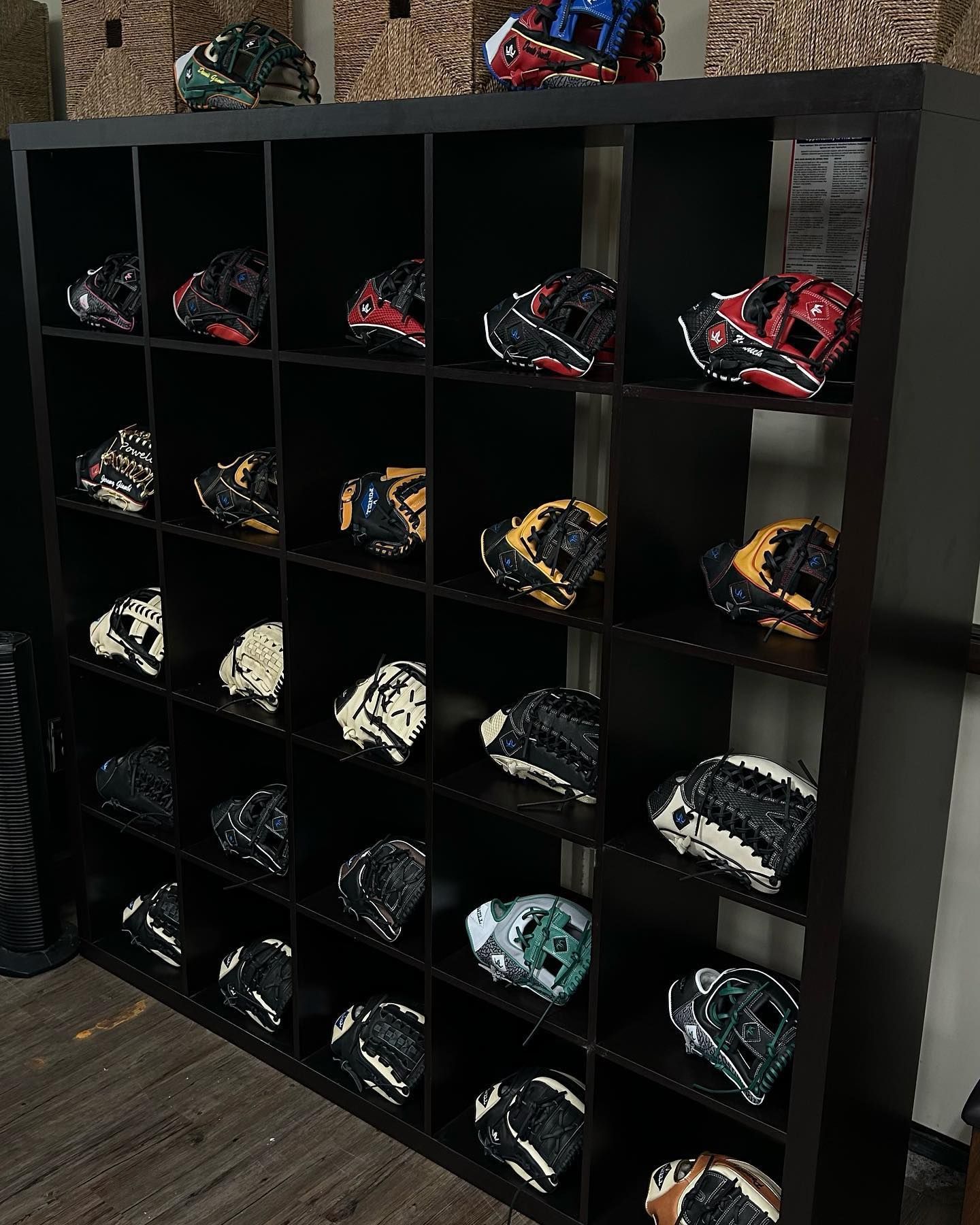 A shelf filled with baseball gloves in a room