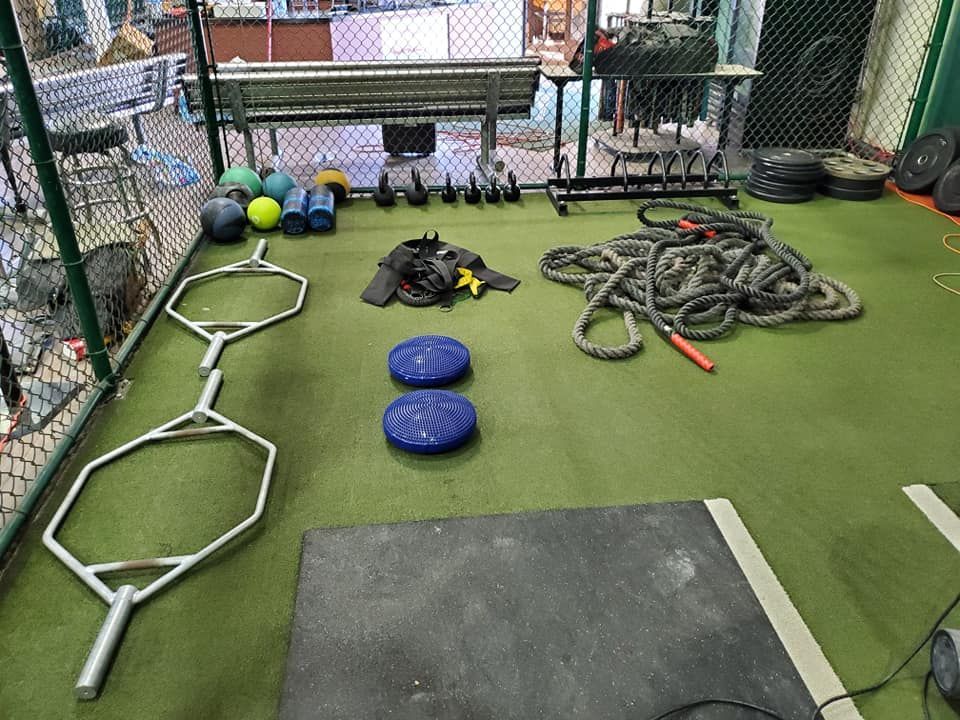 A gym with a lot of exercise equipment on the floor.