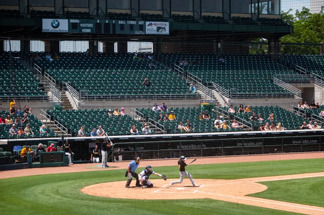 A baseball game is being played in a stadium with empty seats.