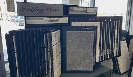 Rows of framed samples and displays arranged on a table in a showroom or office setting