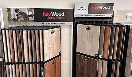 ReVWood flooring display with samples in a showroom, showing light and dark wood finishes