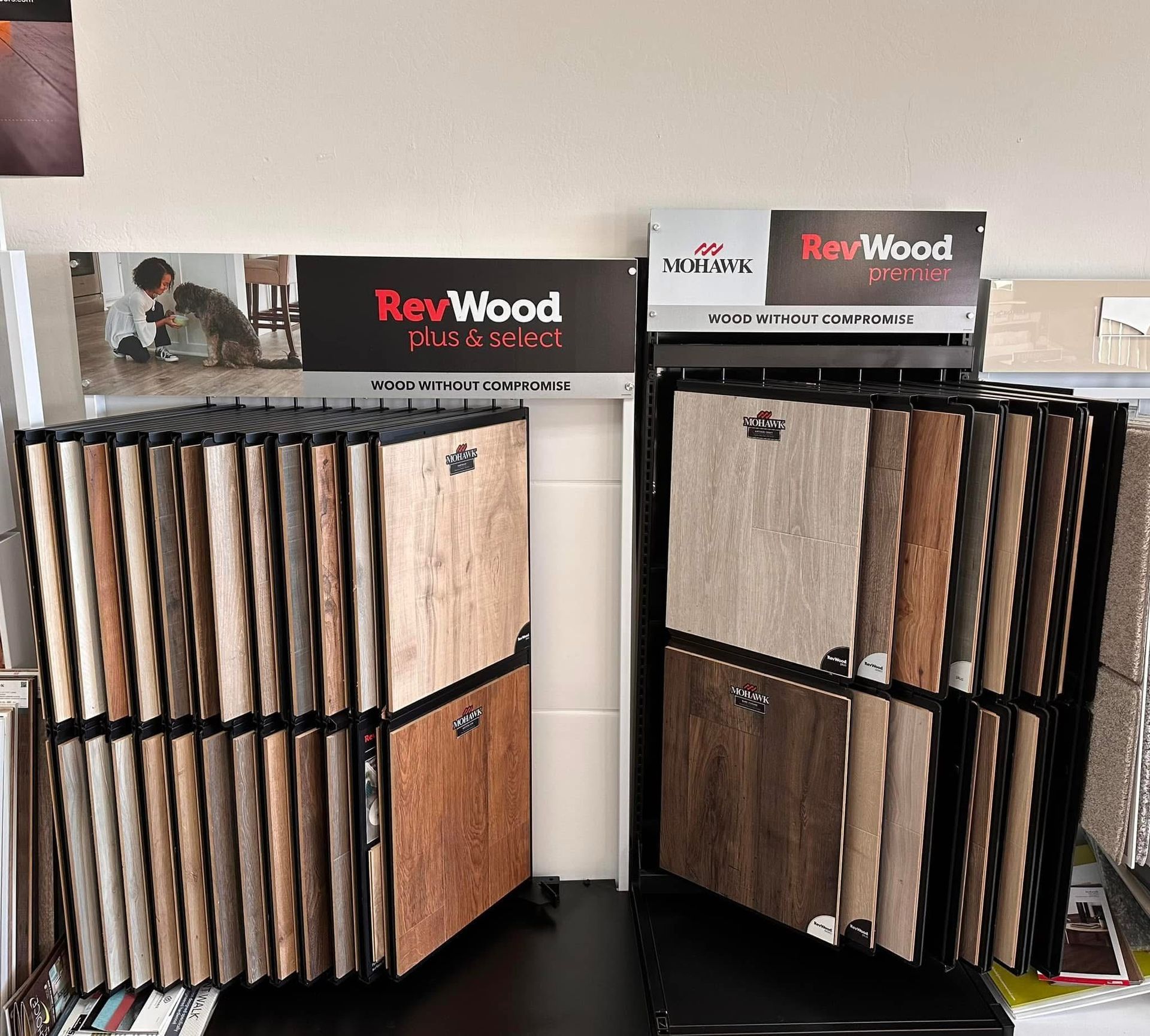 Display of wood and laminate sample boards with RevWood signs in a showroom