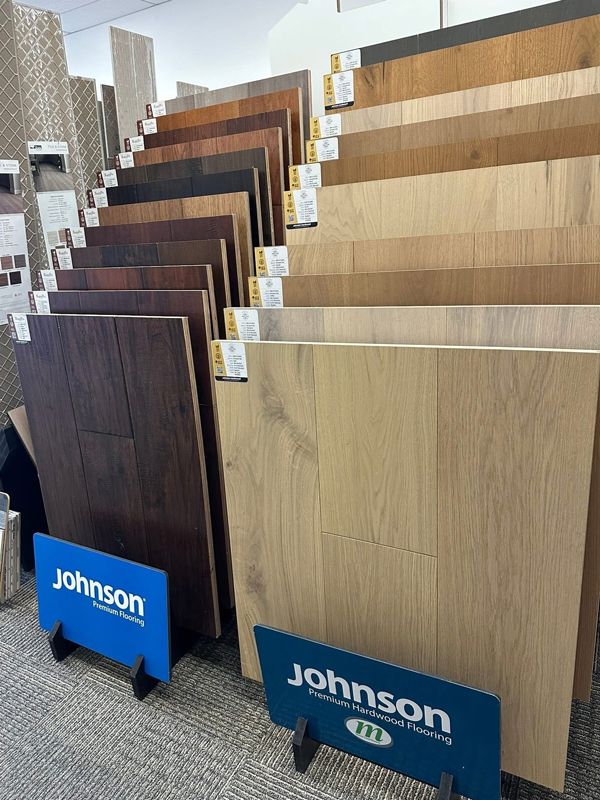 Display of wood floor samples on stands with Johnson branding in a showroom