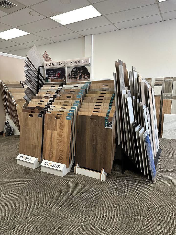 Display of wood flooring samples on racks in a showroom under bright ceiling lights