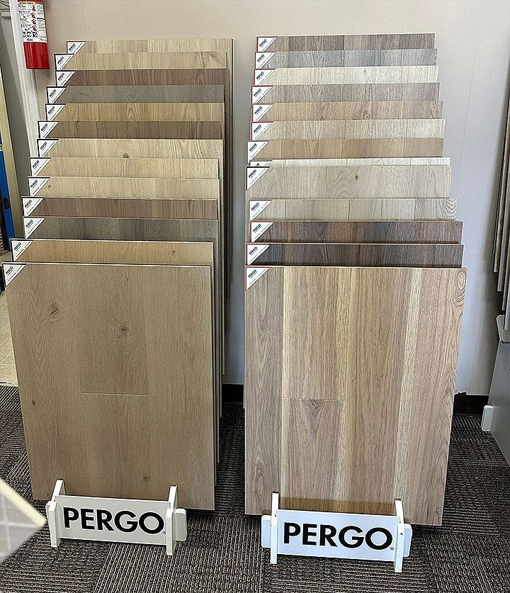 Two display boards of Pergo flooring samples in light and dark wood tones