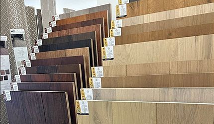 Rows of wood flooring samples in a showroom, showing varied brown and beige finishes