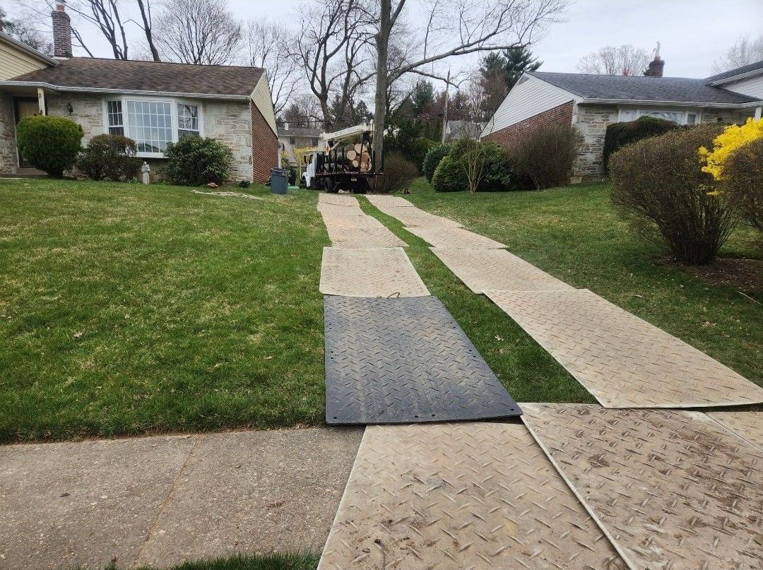 A concrete walkway leading to a house in a residential area.