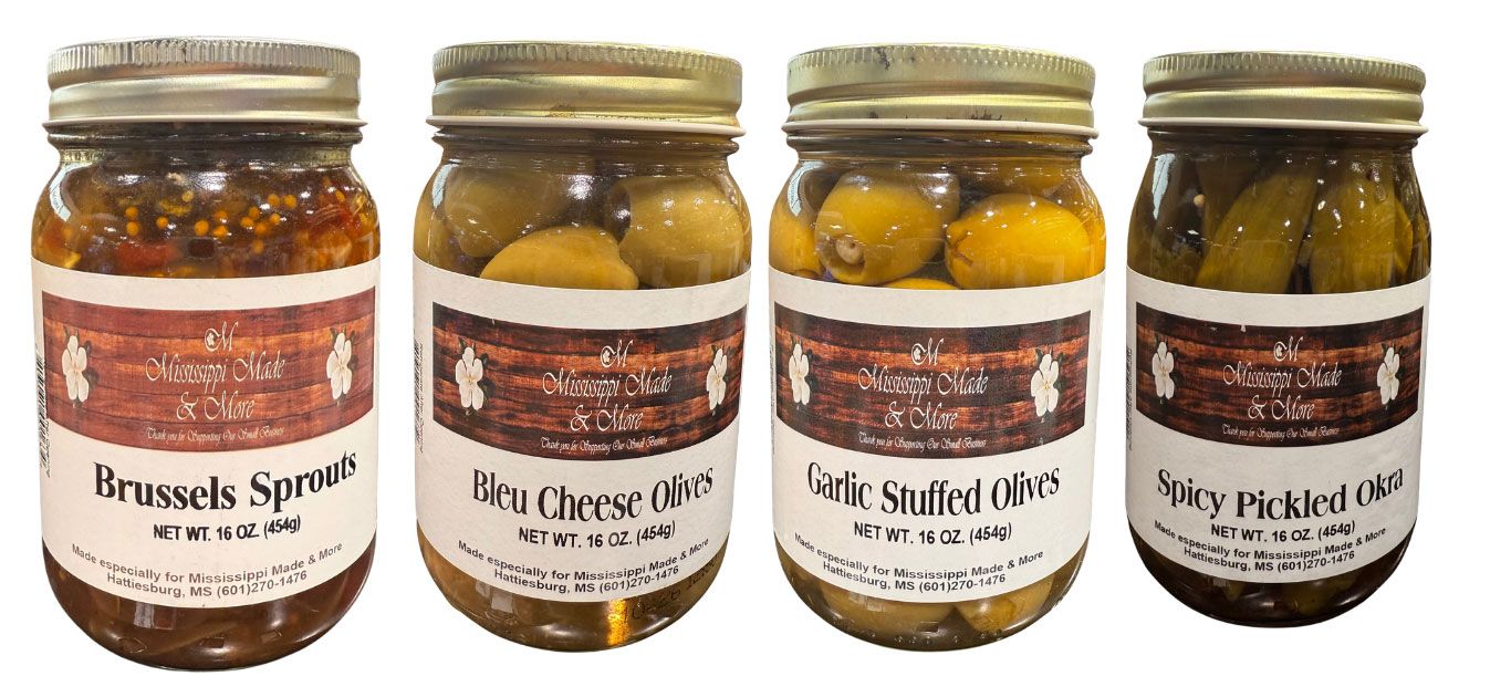 Four jars of pickled vegetables with handwritten labels on a white background