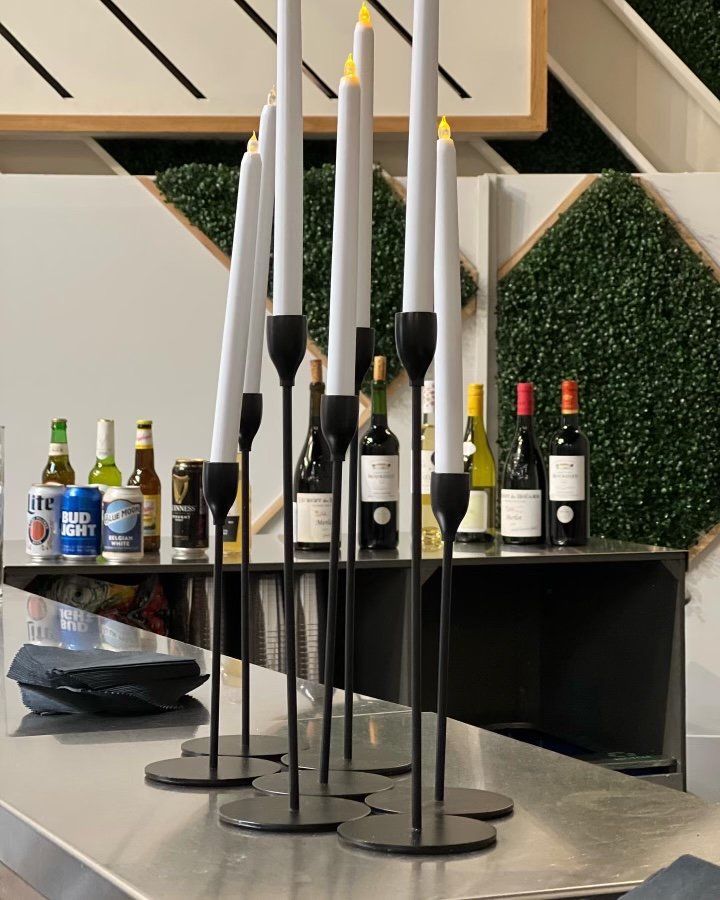 A bar with bottles of beer and candles on it