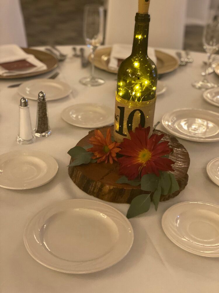 A table with plates and a bottle of wine with the number 10 on it.