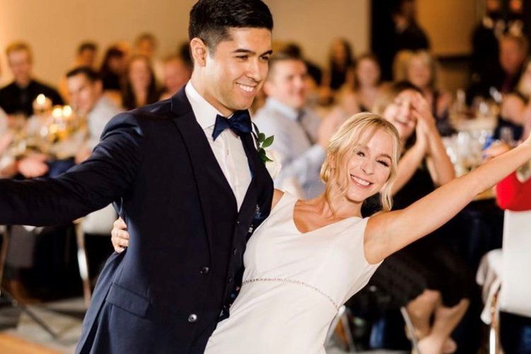 A bride and groom are dancing at their wedding reception.