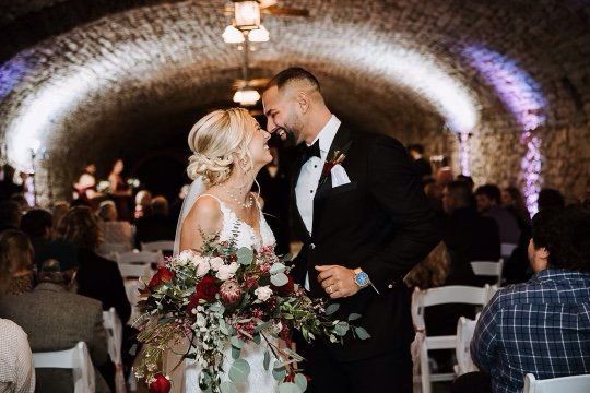 A bride and groom are walking down the aisle at their wedding.
