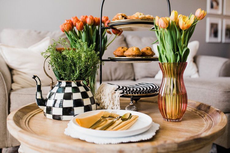 A coffee table with plates , utensils , and flowers on it.