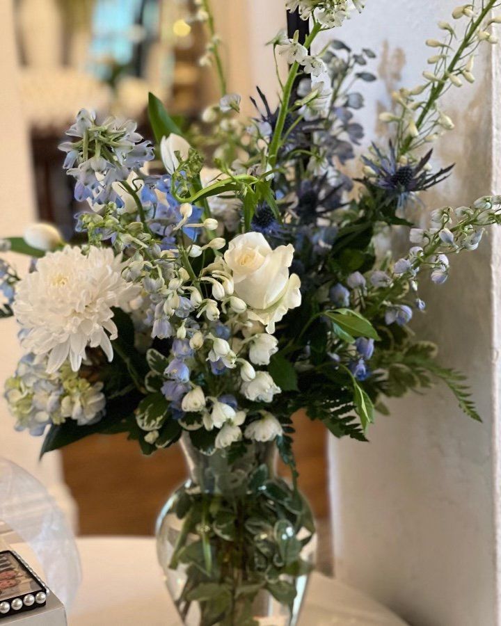 A large room with tables and chairs set up for a wedding reception.