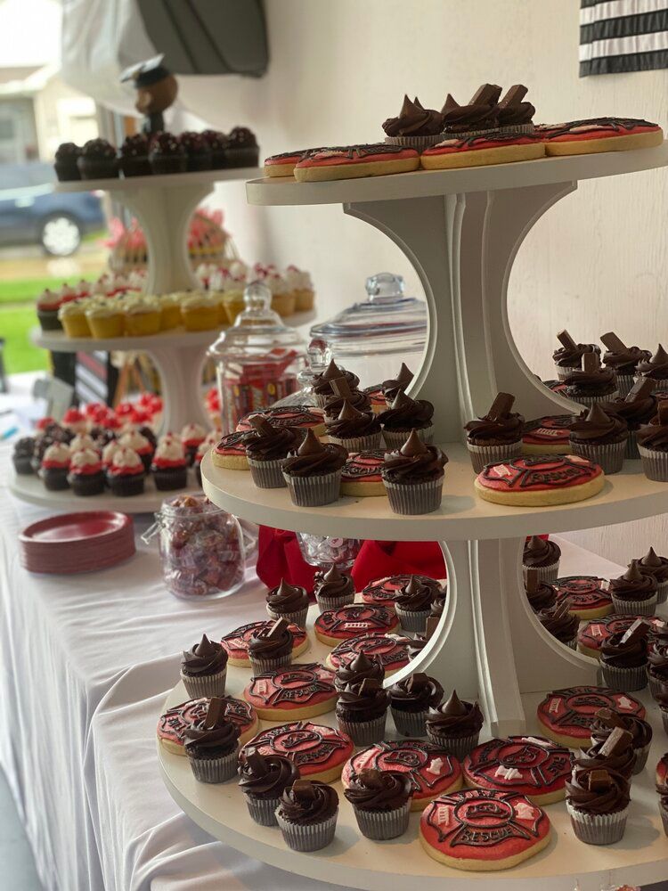 A cupcake tower filled with cupcakes and donuts on a table.