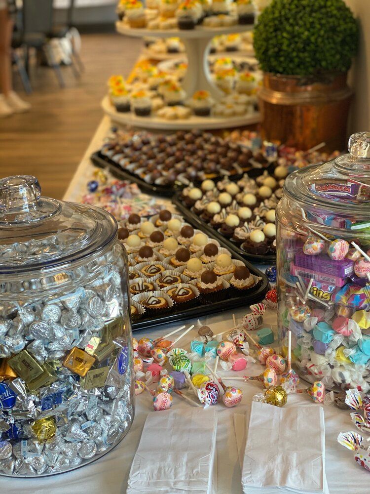 A table topped with jars of candy and cupcakes.