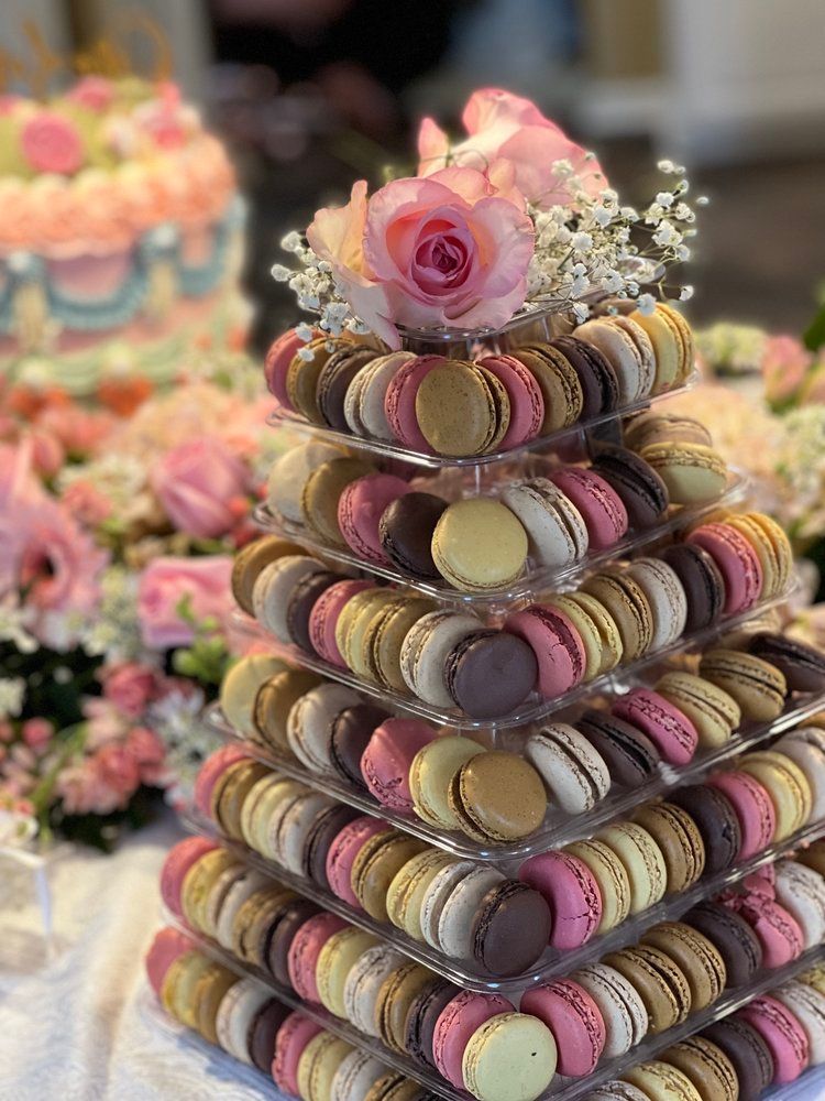 A stack of macarons with flowers on top of them on a table.