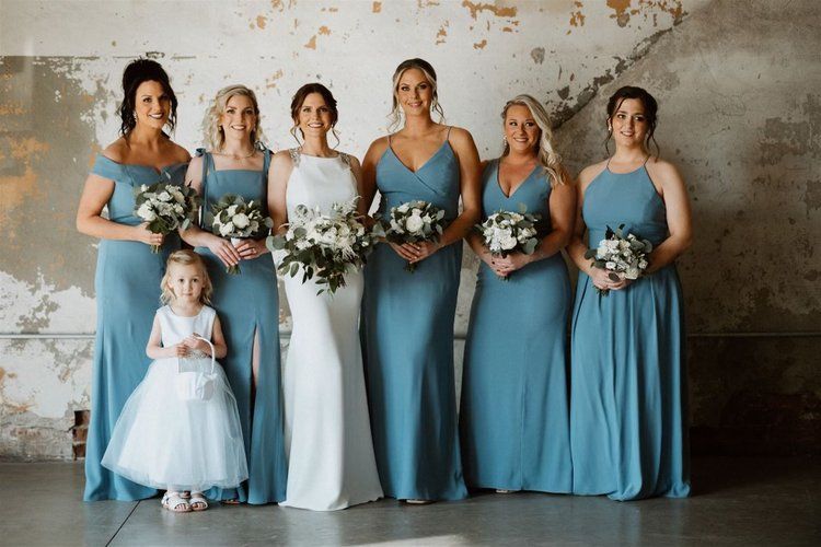 A bride and her bridesmaids are posing for a picture.