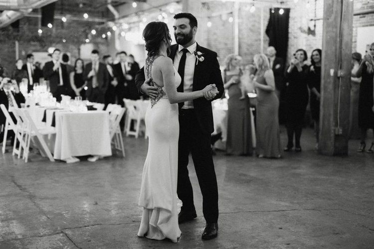 A black and white photo of a bride and groom dancing at their wedding reception.