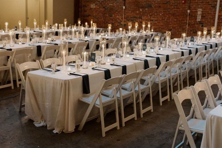 A long row of tables and chairs set up for a wedding reception.