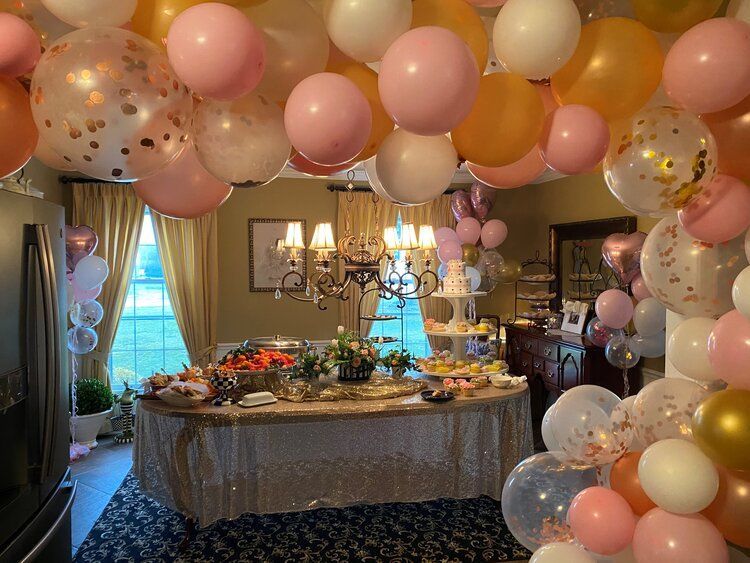 A room with a table and balloons hanging from the ceiling.