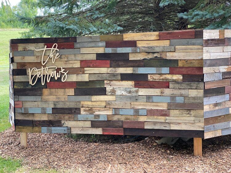 A wooden wall with the name of the owners written on it.