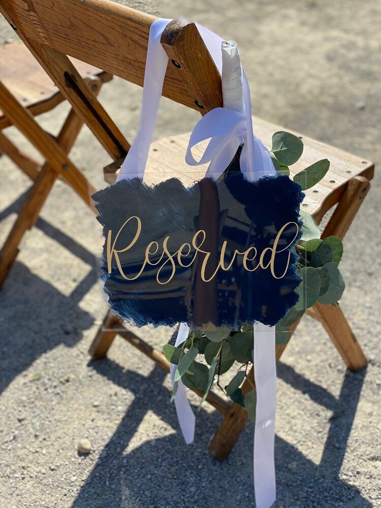 A reserved sign is hanging from a wooden chair.