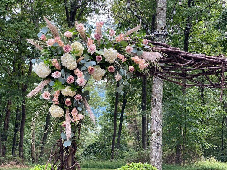 A row of wooden chairs are lined up in front of a building for a wedding ceremony.