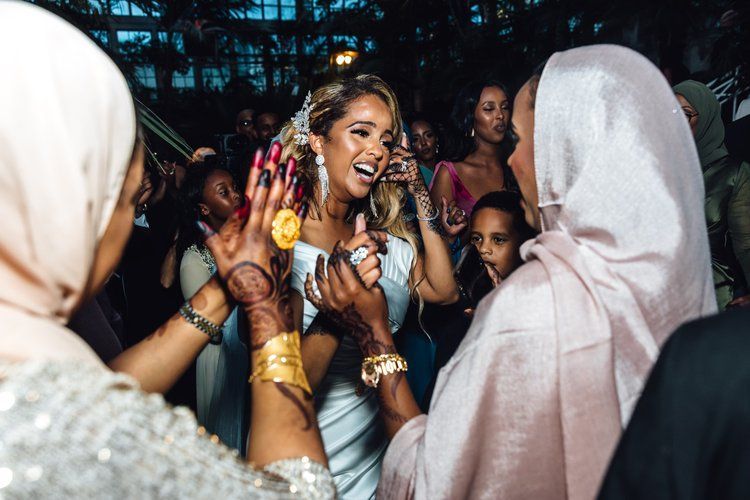 A woman in a white dress is dancing in a crowd of people.