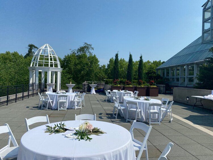 A patio with tables and chairs set up for a wedding reception.