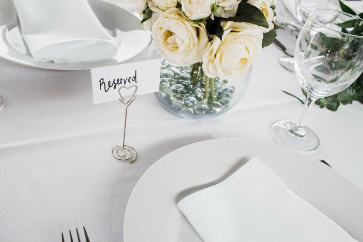A white plate with a reserved sign on it is on a table.