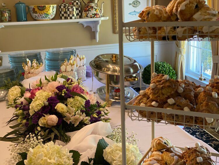 A table with a bunch of food and flowers on it.