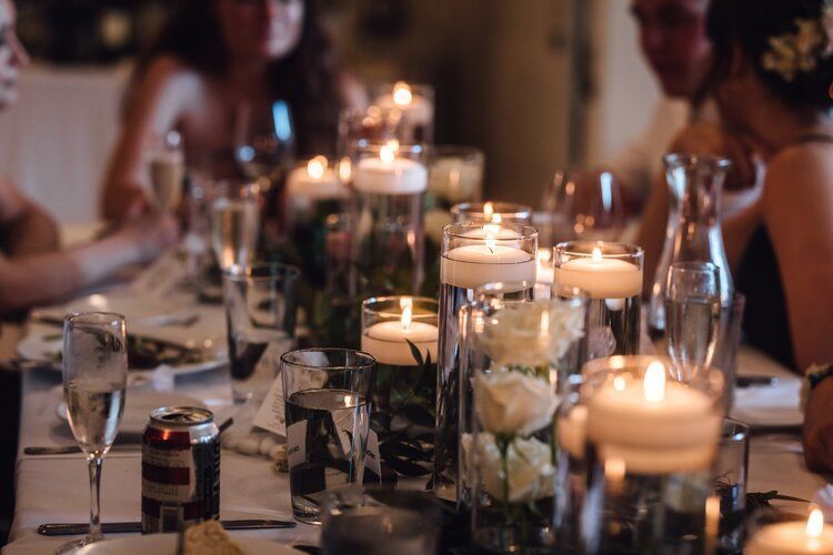 A group of people are sitting at a table with candles and wine glasses.