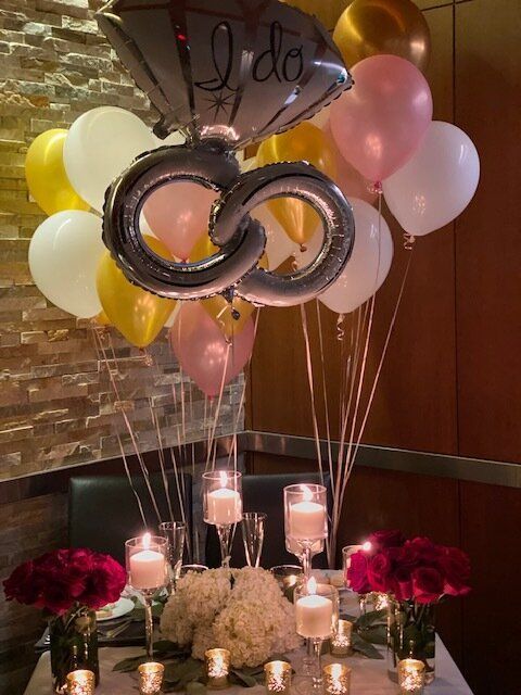 A table with balloons and candles and a balloon that says i do