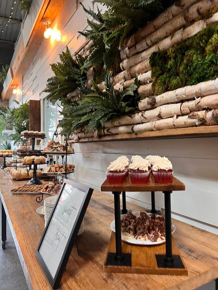 A wooden table topped with cupcakes and a picture frame.