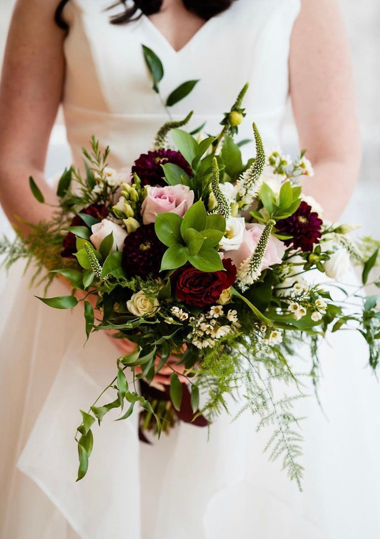 A bride in a white dress is holding a bouquet of flowers.