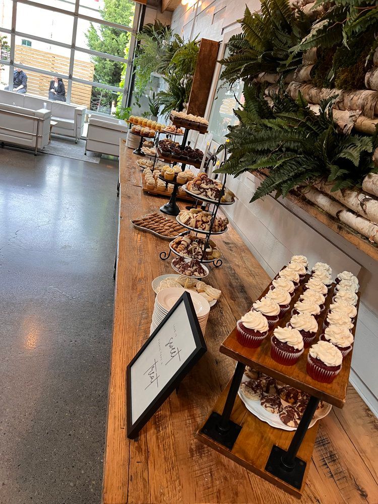 A wooden table topped with cupcakes and other desserts.