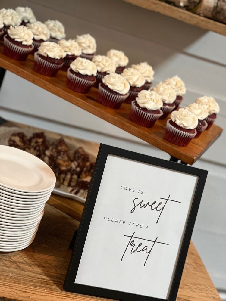 A table with cupcakes and a sign that says `` love a sweet treat ''.