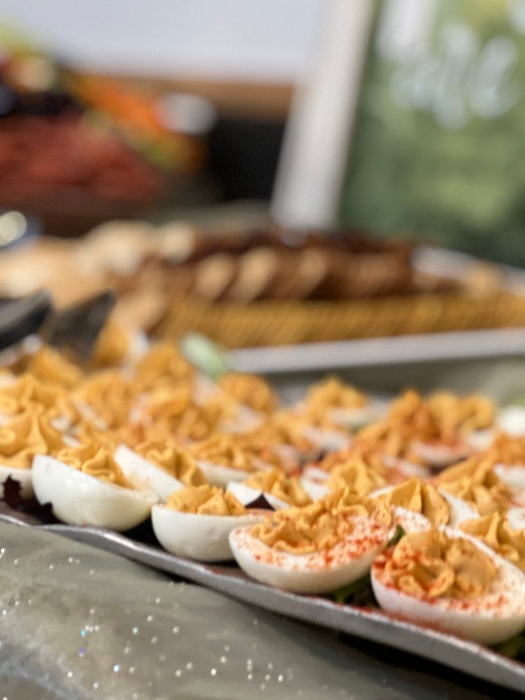 A tray of stuffed eggs with noodles on a table