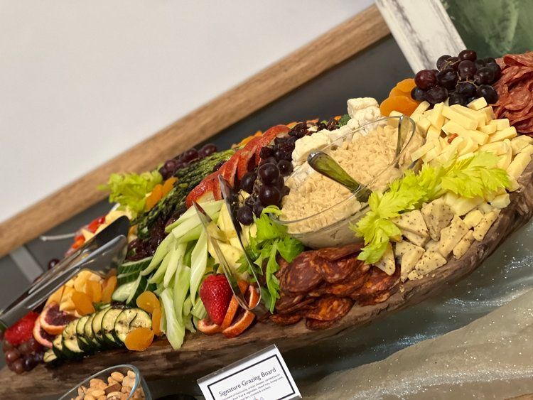 A wooden tray filled with fruits and vegetables on a table.