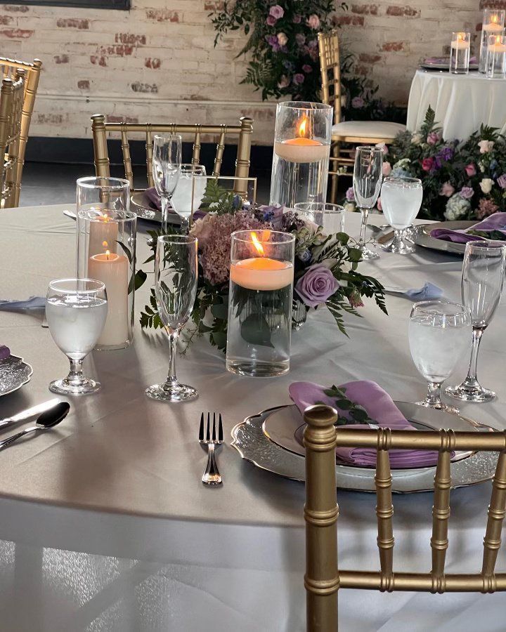A table set for a wedding reception with candles and flowers