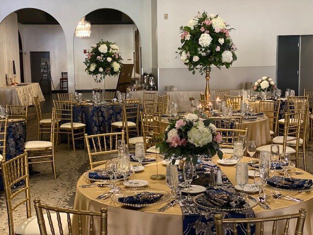 A large room with tables and chairs set up for a wedding reception.
