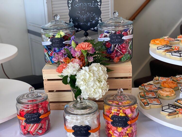 A table with jars of candy and cookies on it