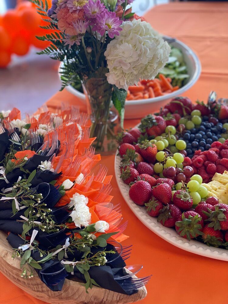 A table topped with plates of fruit and flowers.
