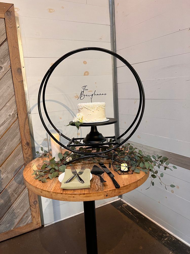 A wedding cake is sitting on top of a wooden table.