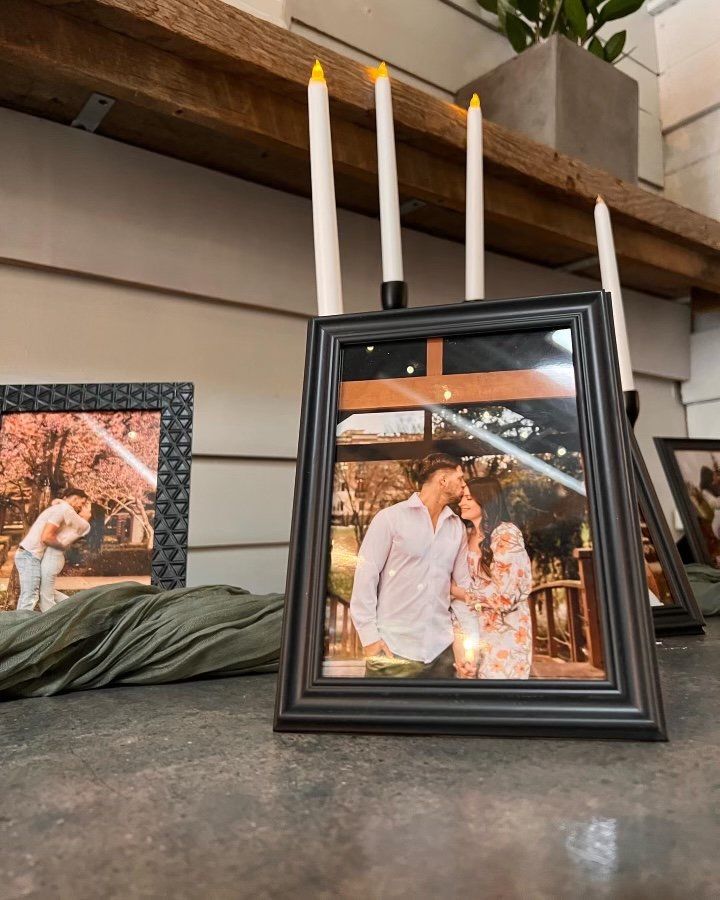A picture of a man and woman in a frame with candles in the background